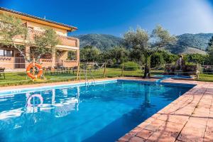 a swimming pool in front of a house at Hotel Rural Hosteria Fontivieja in Losar de la Vera