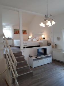 a bedroom with a bed and a staircase with a television at Ferienwohnung Weitblick in Wolfshagen