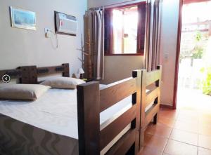 a bedroom with two beds and a window at Pousada Seachegue in Ubatuba