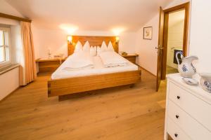 Schlafzimmer mit einem Bett mit weißer Bettwäsche und Kissen in der Unterkunft Haus Jäger in Filzmoos