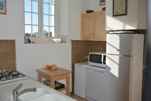 a kitchen with a white refrigerator and a microwave at Vue imprenable sur la mer à Batz sur Mer in Batz-sur-Mer