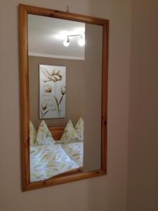 an der Wand hängt ein Spiegel mit einem Bett in der Unterkunft Apartment Knablhof in Sankt Martin am Tennengebirge