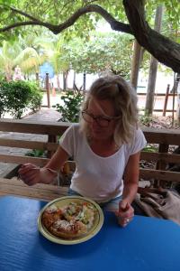 西端的住宿－Hotel Chillies and Native Sons Diving，坐在餐桌上吃一盘食物的女人