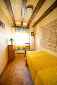 a bedroom with a yellow bed and a window at El Mirador de Messía de Leiva in Segura de la Sierra