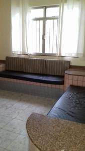 - un long banc dans une chambre avec fenêtre dans l'établissement Apartamento em Piúma-ES, à Piúma