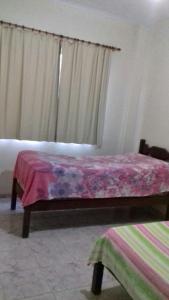 una camera con un letto e una coperta viola di Apartamento em Piúma-ES a Piúma