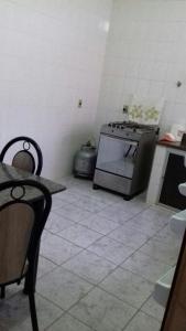 uma cozinha com um fogão e uma mesa em Apartamento em Piúma-ES em Piúma
