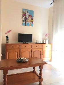 マラガにあるApartamento CENTRICO Mare Nostrumのリビングルーム(テーブル、テレビ付)