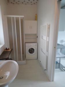 a bathroom with a washing machine and a sink at La Meridiana, monolocale in cascina ristrutturata in Boves