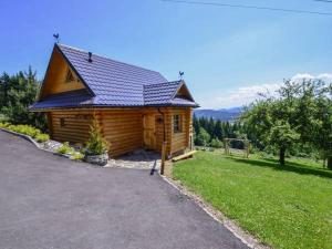 a small wooden cabin with a gambrel roof on a field at Domek drewniany simonka zawoja in Zawoja