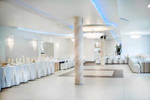 salę bankietową z białymi stołami i białymi krzesłami w obiekcie Pelikan w Aleksandrowie Łódzkim