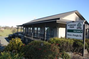 un bâtiment avec un panneau devant lui dans l'établissement Ashbury Park Motel, à Timaru