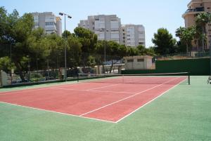 una pista de tenis con una red y edificios al fondo en Costa Blanca Apartment en Alicante