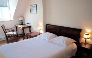 シャルトルにあるles crépinièresのベッドルーム1室(ベッド1台、テーブル、椅子付)