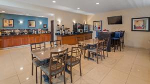 a restaurant with tables and chairs and a bar at Best Western Plus Gas City in Gas City