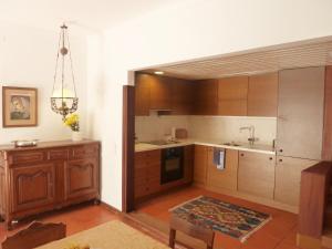 a kitchen with wooden cabinets and a sink and a table at CASA DO LARGO DO COLÉGIO in Évora