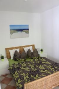 a bedroom with a bed with a black and green bedspread at Ferienwohnung Nienhagen in Nienhagen