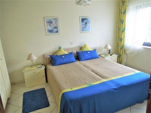 Un dormitorio con una cama con almohadas azules y amarillas. en Haus Traumblick, en Bad Neuenahr-Ahrweiler