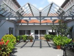 a house with a roof with potted plants in front of it at Hotel Papillon in Lappersdorf