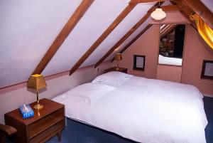 een slaapkamer met een groot wit bed en een tafel bij B&B De Oude Molensteen in Eelde-Paterswolde