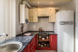 a kitchen with red cabinets and a white refrigerator at Apartment in the city center in Dnipro
