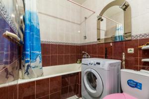a bathroom with a washing machine and a tub at Apartment in the city center in Dnipro