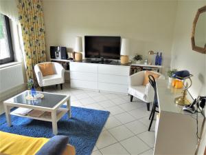Una sala de estar con televisión y un sofá. en Haus Traumblick, en Bad Neuenahr-Ahrweiler