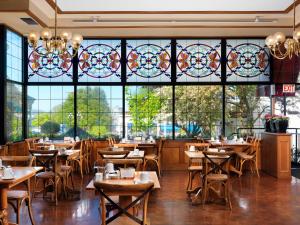 a restaurant with tables and chairs and stained glass windows at Huntingdon Hotel and Suites in Victoria
