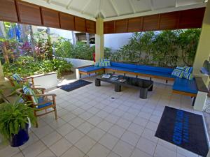 um pátio com um sofá azul, uma mesa e cadeiras em Central Plaza Port Douglas em Port Douglas
