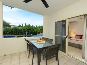 a dining room with a table and chairs on a balcony at Central Plaza Port Douglas in Port Douglas
