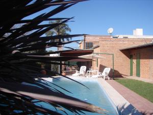 a swimming pool with two chairs and a table at La Niña in Salta
