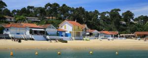 a group of houses on a beach next to the water at Clos Saint Médard in Saint-Médard-en-Jalles