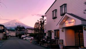 
a street scene with cars parked in front of a building at K's House Fuji View - Travelers Hostel in Fujikawaguchiko
