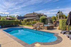 a swimming pool in a yard with a house at Lansdown Peaks Apartments in Wanaka