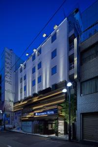 ein Gebäude in einer Stadtstraße in der Nacht in der Unterkunft Centurion Hotel&Spa Ueno Station in Tokio