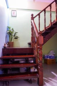 una scala in legno in una stanza con una pianta di Zleep63 a Bangkok
