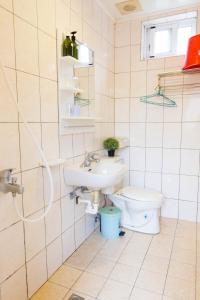 a bathroom with a sink and a toilet at Yahu Hotel in Fenchihu