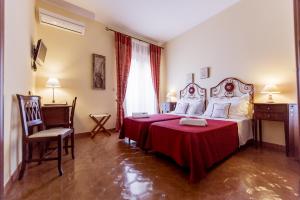 een slaapkamer met een bed en een tafel en stoelen bij San Pietro in Noto