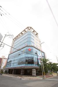 a large glass building on the corner of a street at Dong Gyeong Hotel in Tongyeong