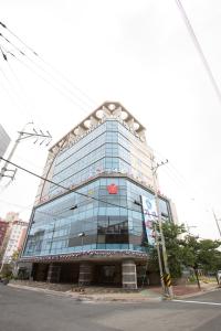 een groot glazen gebouw op de hoek van een straat bij Dong Gyeong Hotel in Tongyeong