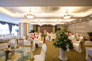 a banquet hall with white tables and chairs and chandeliers at Dong Gyeong Hotel in Tongyeong