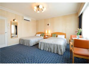 Кровать или кровати в номере Hotel Grand Plaza Urashima