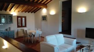 een woonkamer met een witte stoel en een tafel bij Podere Le Volte degli Angeli in Spello