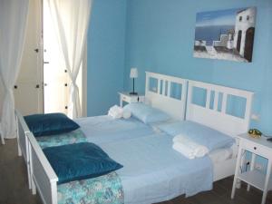 1 dormitorio con paredes azules y 1 cama con 2 almohadas en Gli dei e le Rose, en Agerola