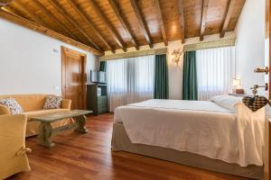 a bedroom with a large bed and a couch at La capr'allegra in Gallio