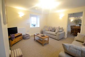 sala de estar con sofá y TV en Rural Coastal Self-Catering Accommodation for 8, Near Sandringham Estate, Norfolk, en Ingoldisthorpe