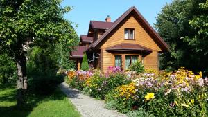 una casa con un jardín de flores delante de ella en Kwiatowa Zagroda, en Białowieża