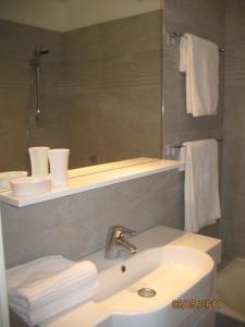La salle de bains est pourvue d'un lavabo, d'un miroir et de serviettes. dans l'établissement Les Hameaux, à Bandol
