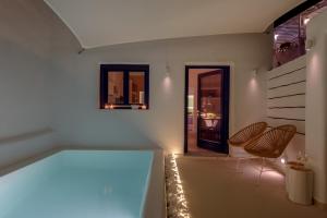 Cette chambre dispose d'une piscine avec des chaises et une table. dans l'établissement Sea Dream Luxury Home, à Fira