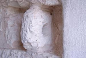 a sculpture of a face on the side of a wall at Masseria Valente in Ostuni